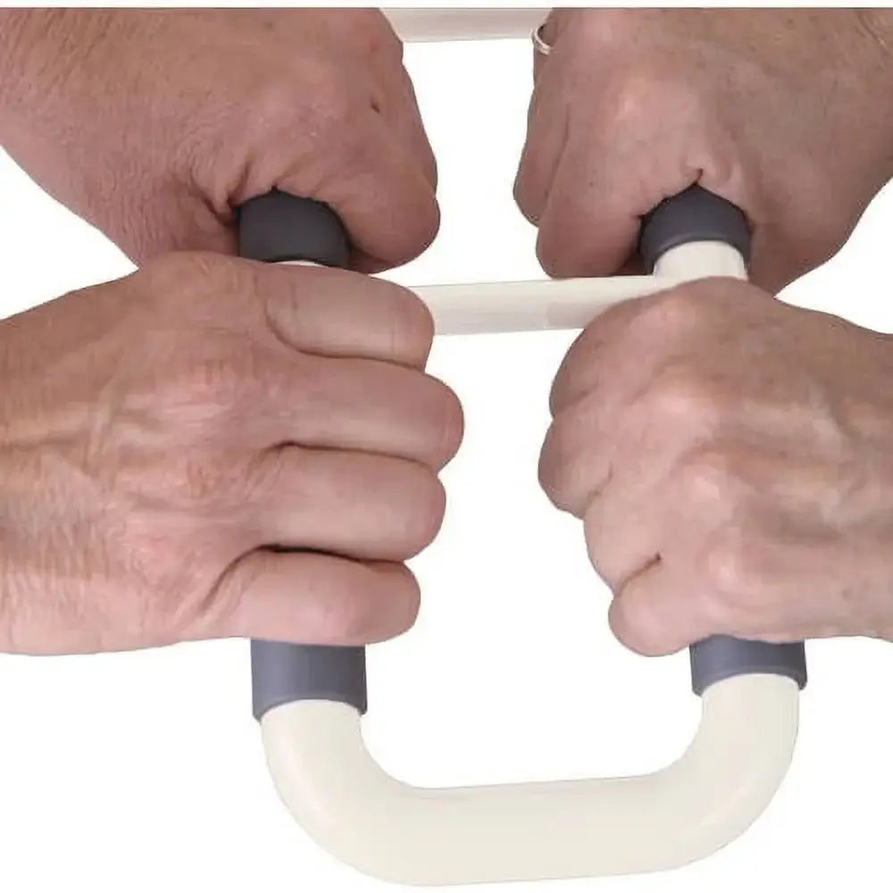 Bed or chair stand assist handle with dual gray grips being held by both hands of an older adult