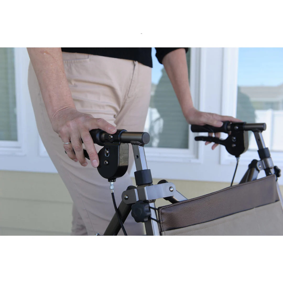Rollator handlebar brake mechanism close-up with person gripping both handles outdoors on a porch