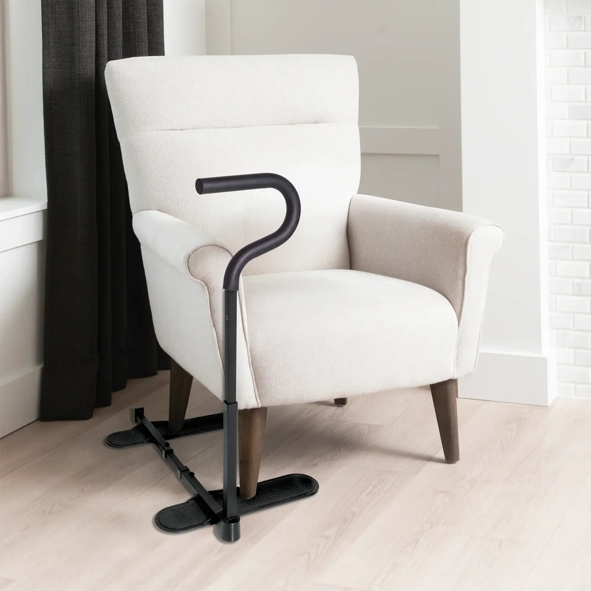 Chair cane with curved handle and freestanding base positioned beside a cream upholstered armchair on light hardwood floor