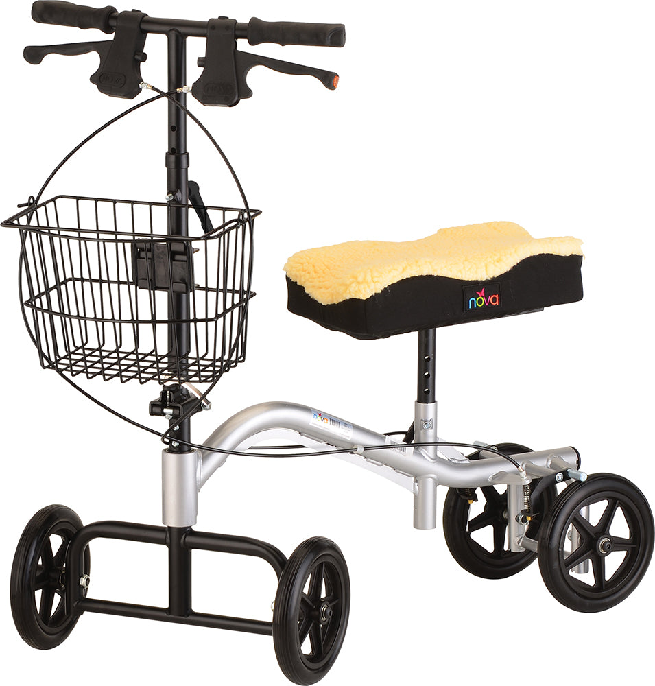 Knee walker with sheepskin-padded knee rest, hand brakes, wire basket, and four black wheels on a silver frame