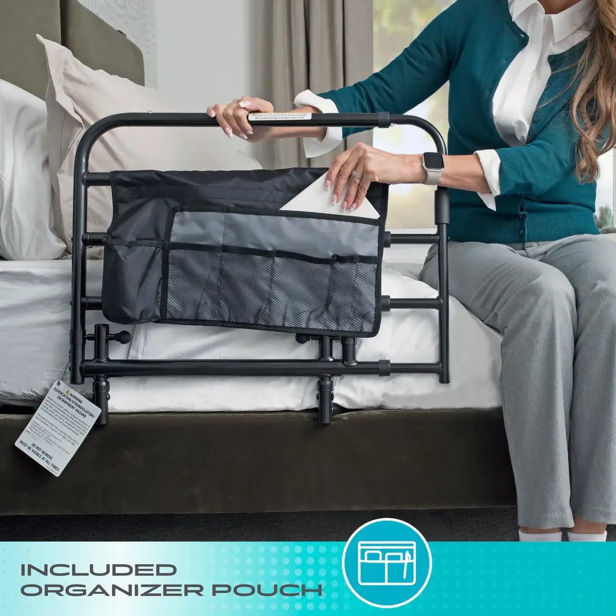 Bed rail with attached organizer pouch shown beside seated woman on bed, highlighting included storage accessory