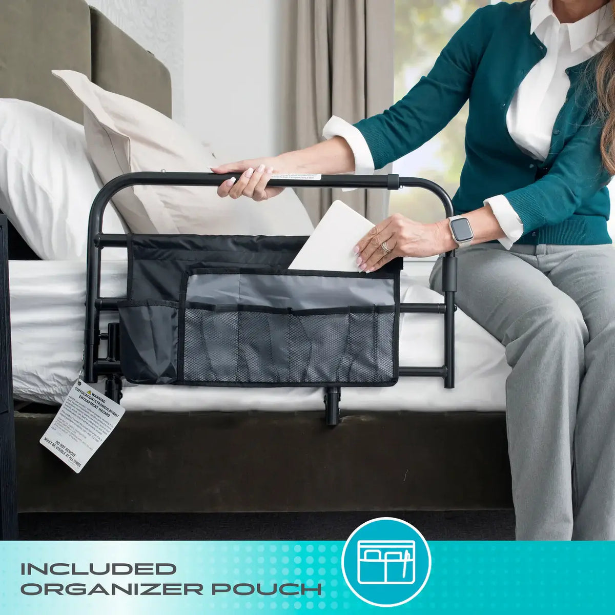 Bed rail with attached black organizer pouch shown on a bed as a woman places an item inside the storage pocket