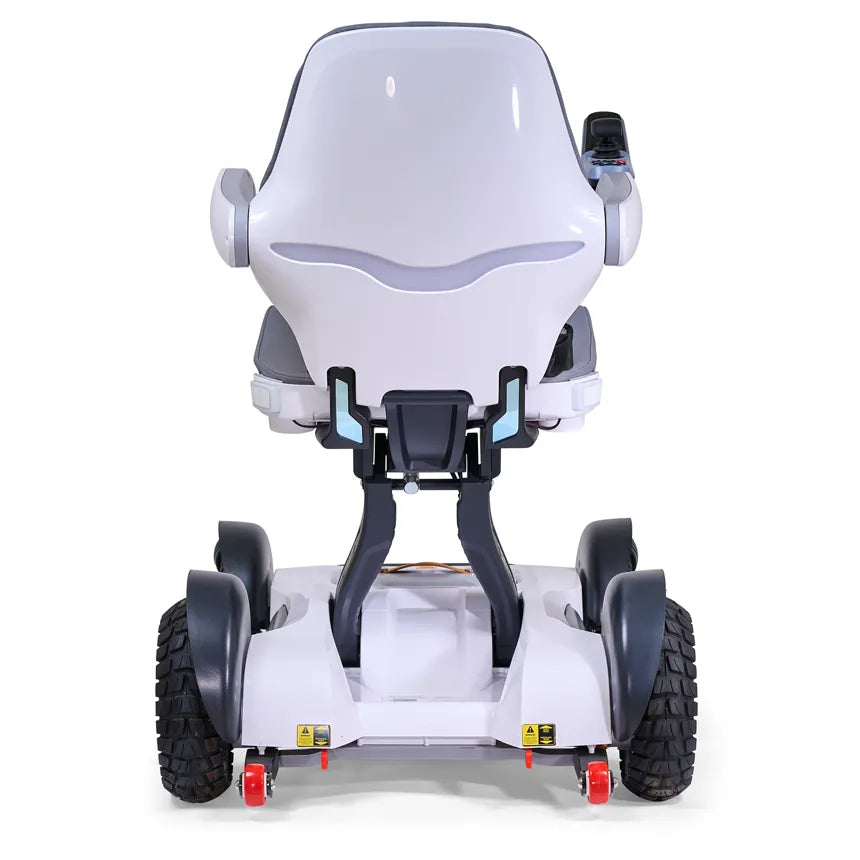 Power wheelchair with white molded seat, gray armrests, joystick controller, four large black tires, and red caster wheels