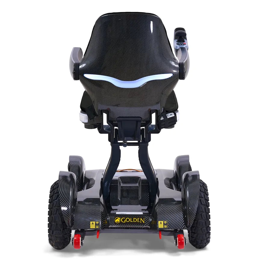 Golden Technologies Ally Sport power wheelchair in carbon fiber finish, rear view showing four all-terrain wheels and blue