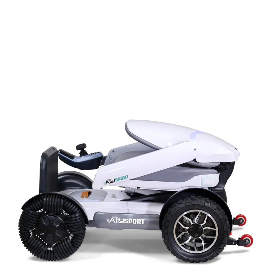 Power wheelchair in folded position with white body panels, joystick controller, and rugged all-terrain tires, shown from