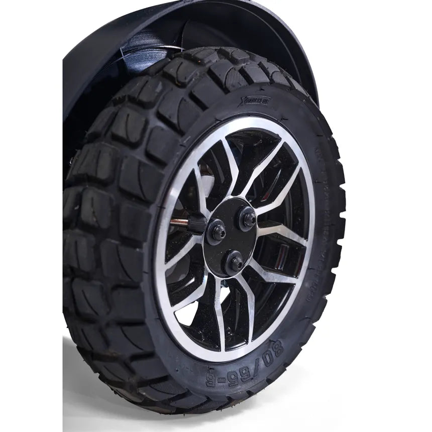 Power wheelchair wheel with deep-tread all-terrain tire and silver multi-spoke alloy hub, shown with black fender