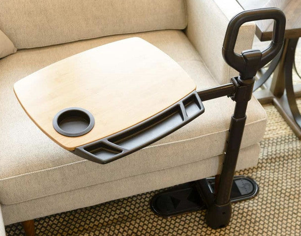 Couch stand assist handle with attached wooden tray and cup holder resting on a beige sofa armrest