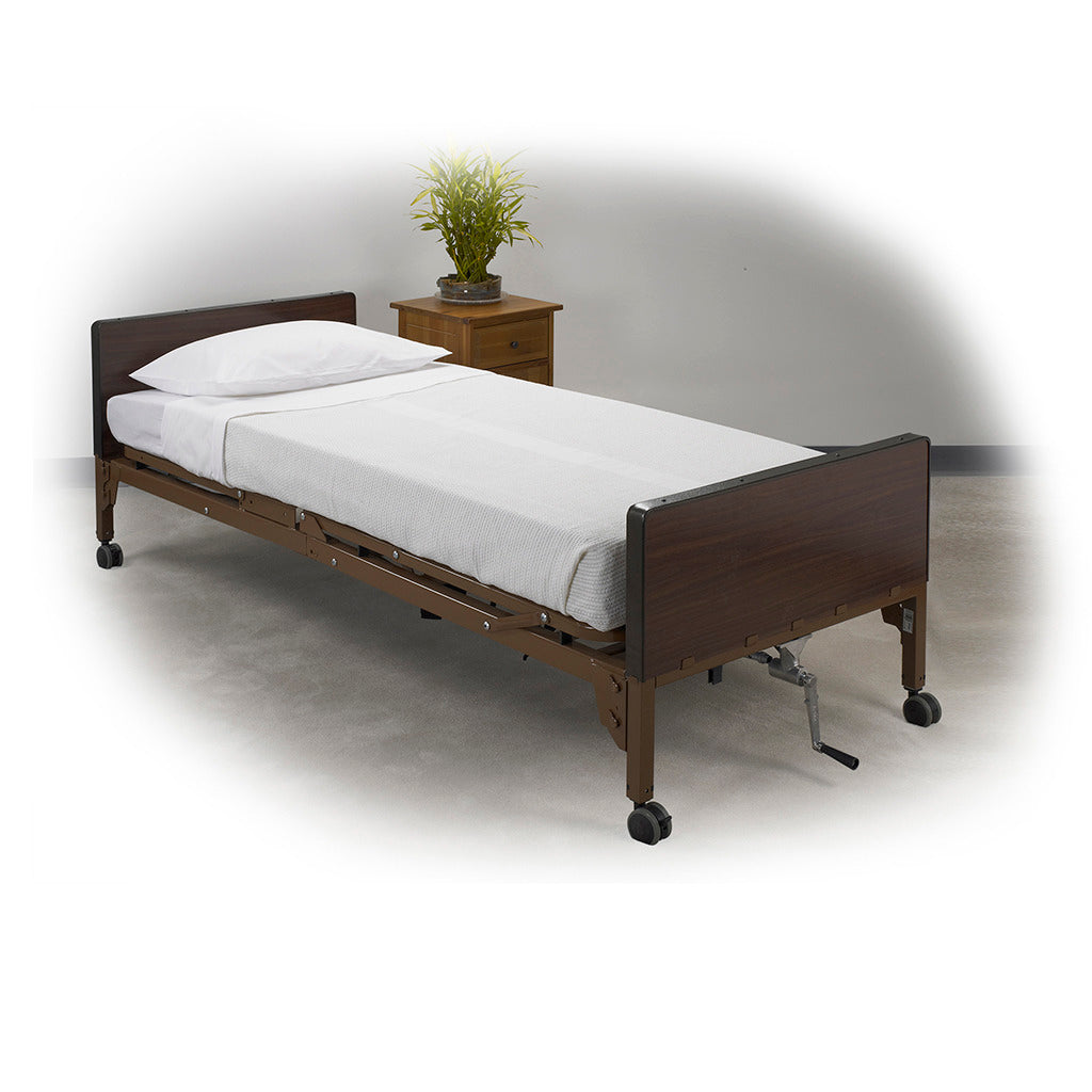 Hospital bed made up with white sheets and pillow, featuring dark wood panels, metal crank, and caster wheels beside a
