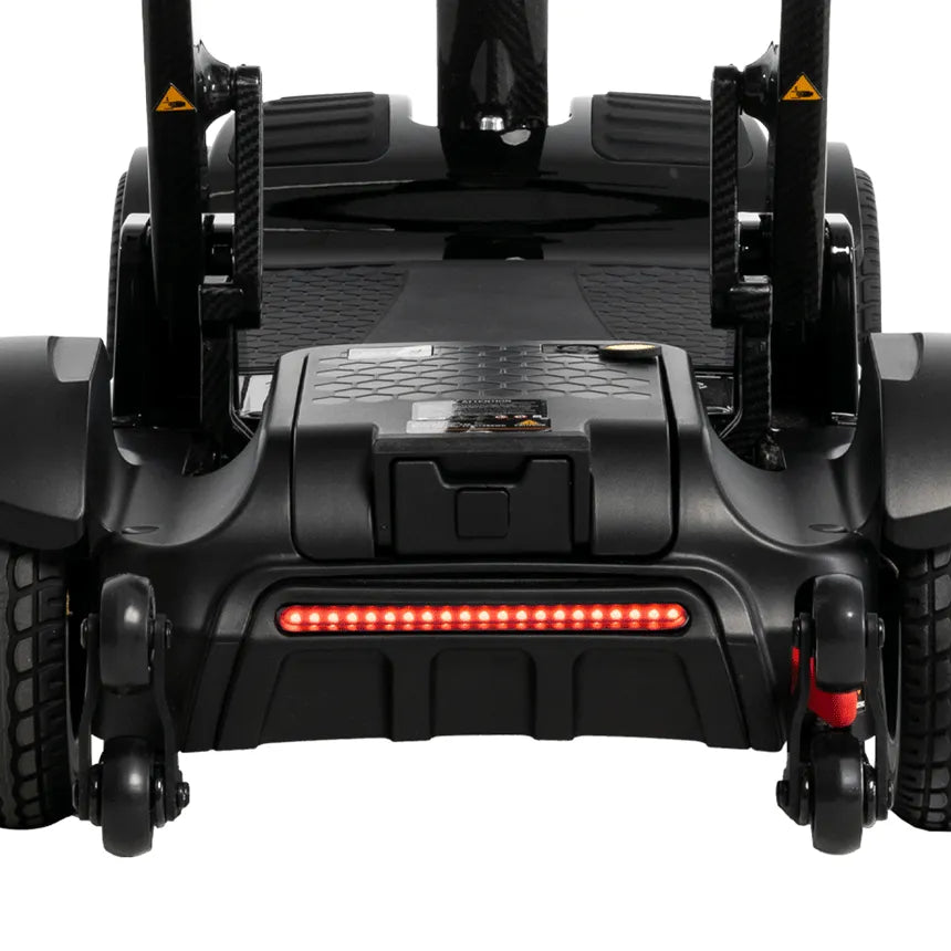 Power scooter rear view in black showing LED tail light, battery compartment, textured footboard, and dual rear wheels