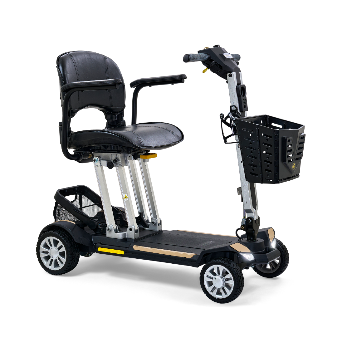 Folding power mobility scooter in black and gold with four wheels, padded seat, tiller controls, and front storage basket