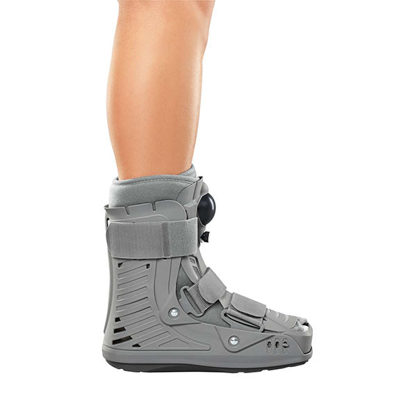CAT Walker Short Boot in gray worn on a bare leg, shown from the side with straps and a dial closure system