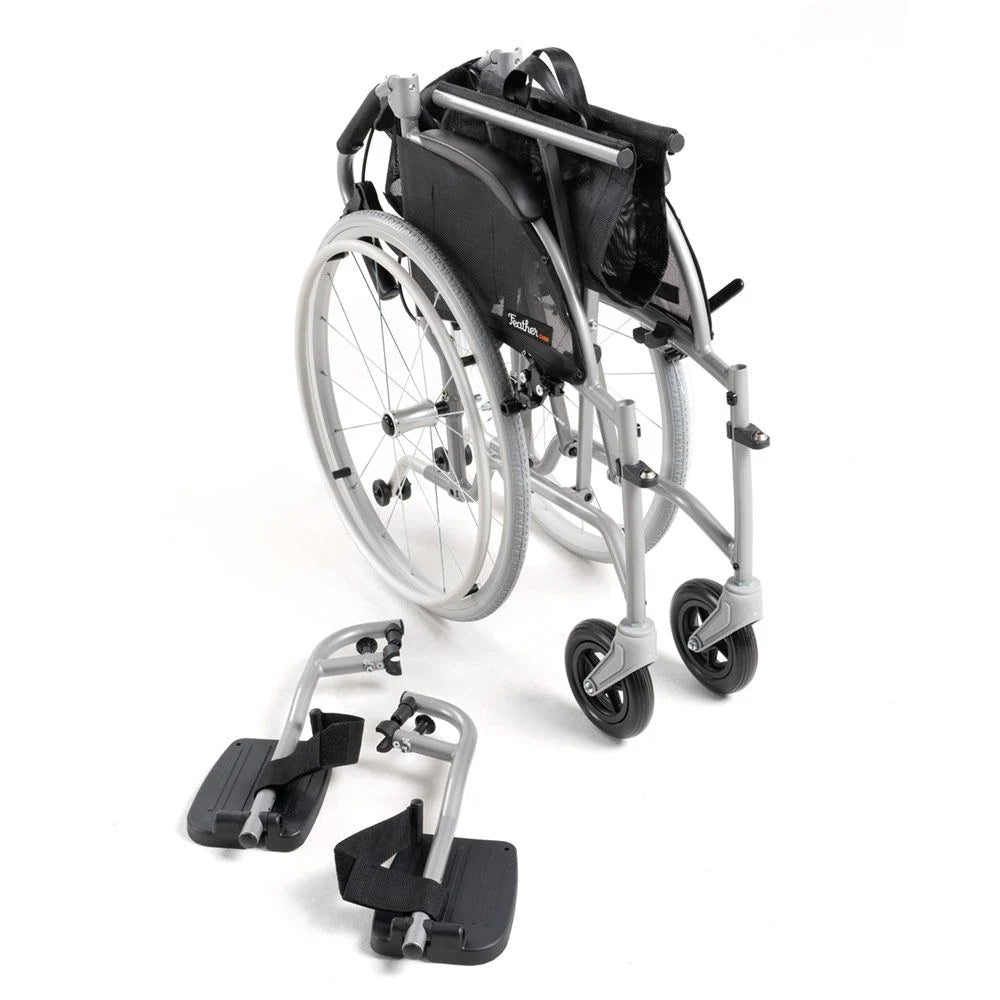 Lightweight manual wheelchair with silver frame, black upholstery, rear view, with detached footrests placed in front on