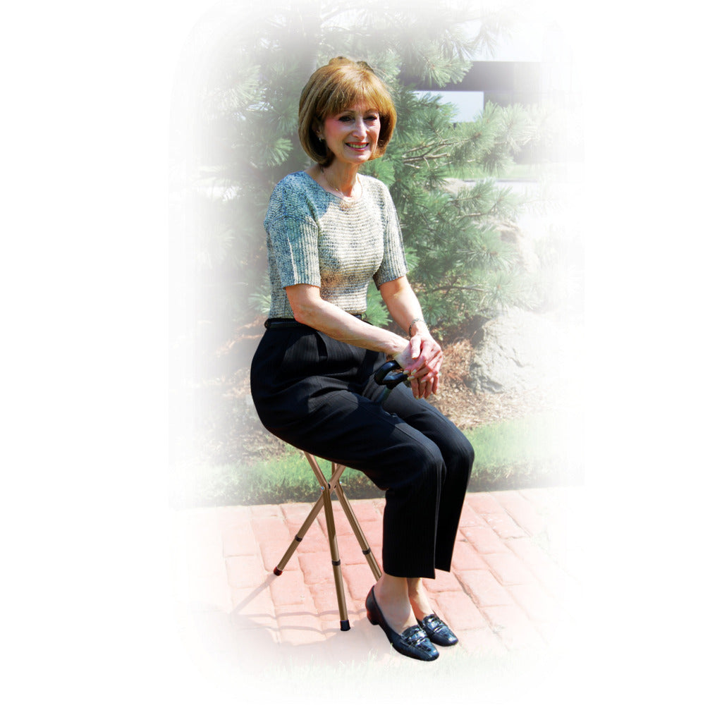 Folding cane seat with tripod base supporting a seated woman outdoors on a brick patio
