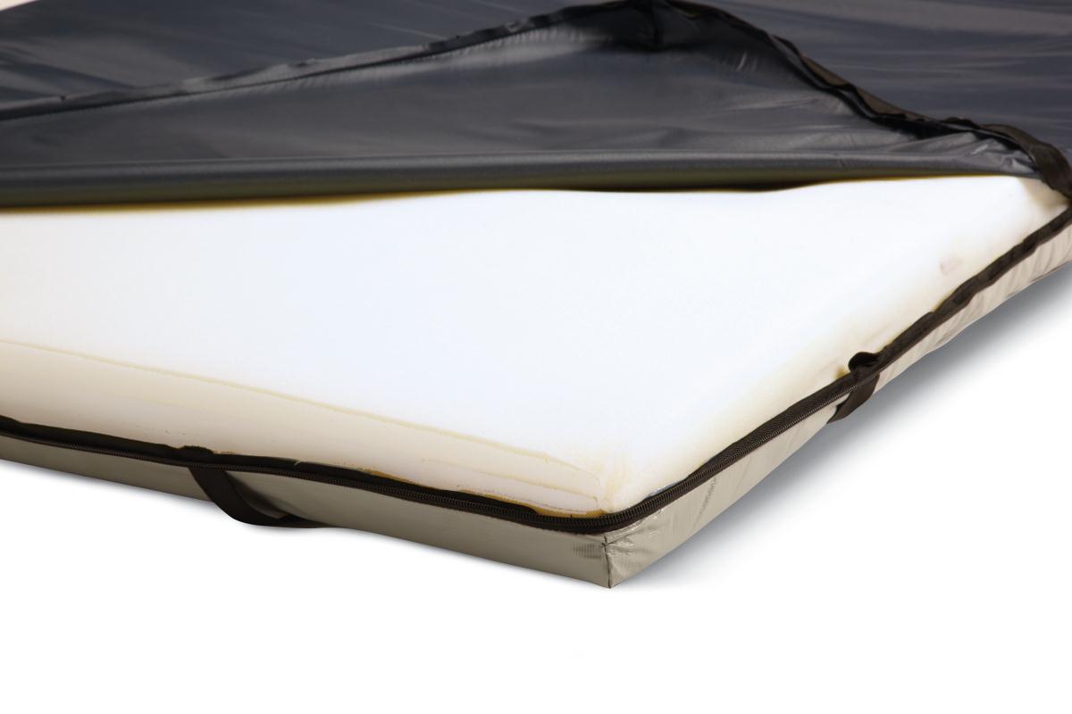 Gel foam mattress overlay with dark vinyl cover partially unzipped, revealing white foam interior and zippered edge