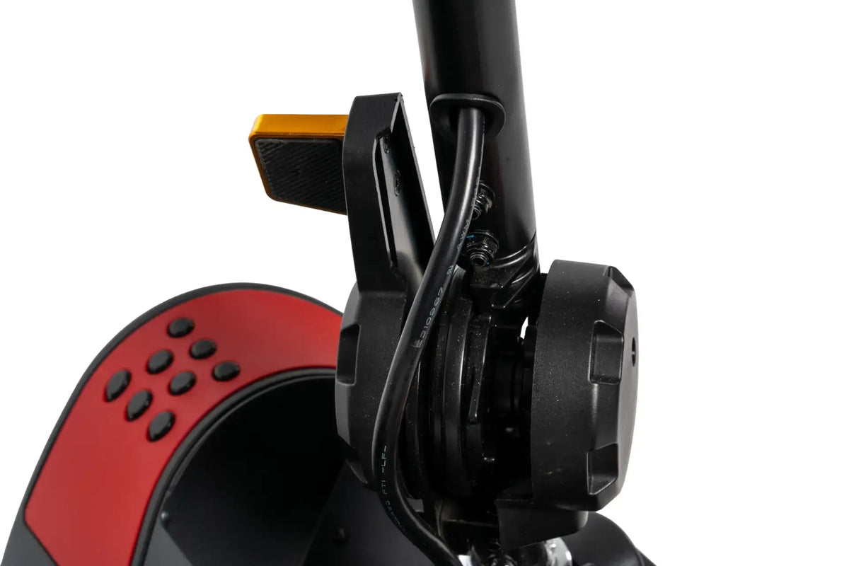 Power scooter tiller close-up showing black folding mechanism, brake lever, and red control panel with buttons