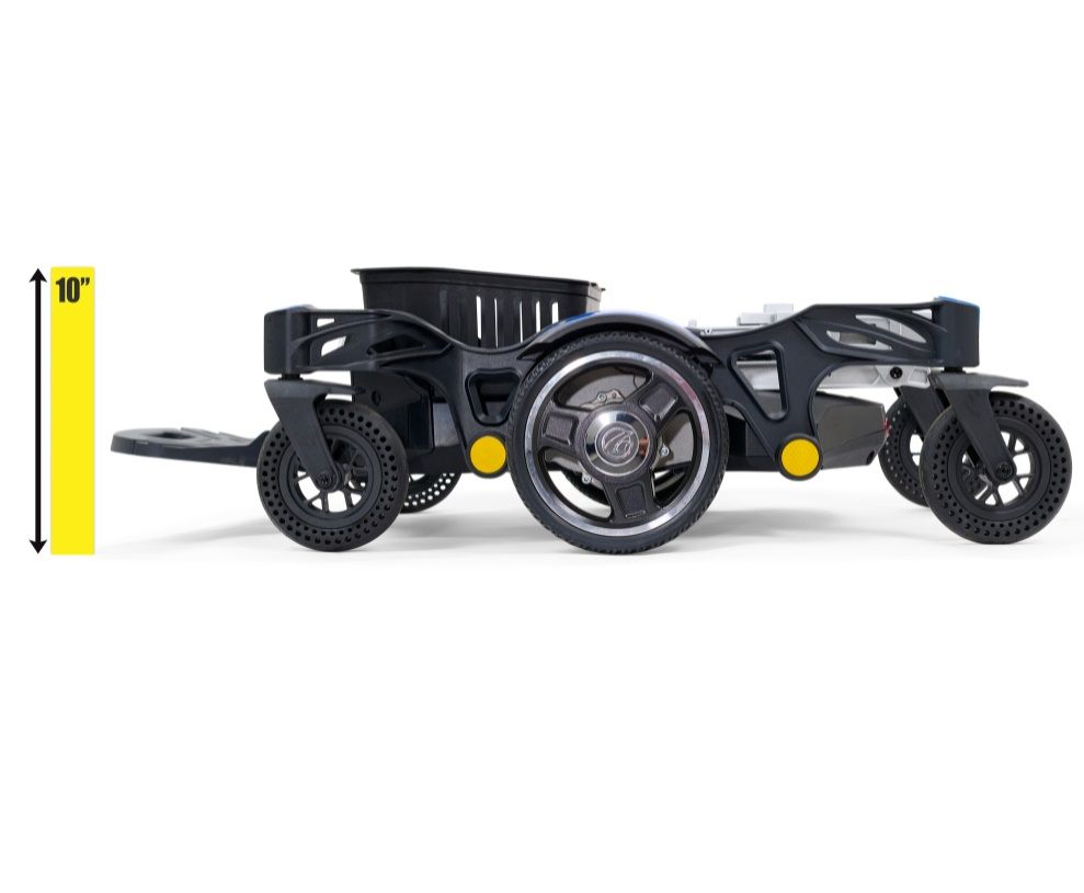 Power wheelchair folded flat showing low-profile height with storage basket, chrome rear drive wheel, and small front and