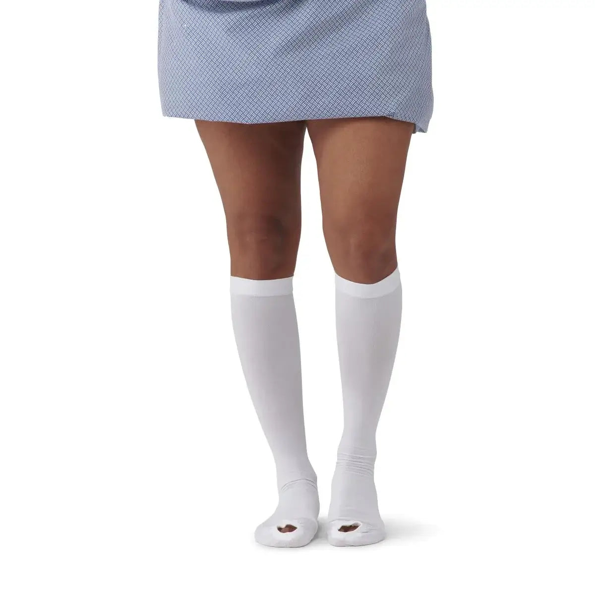 Knee-length anti-embolism stockings in white with open toe, worn on a woman's legs, shown from behind