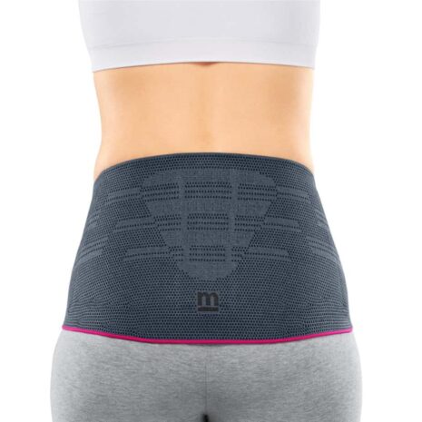Lumbamed Plus lumbar support belt in gray with pink trim worn on a woman's lower back, rear view