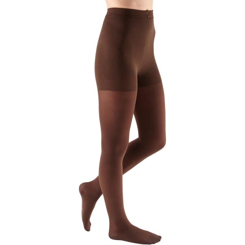 Compression pantyhose in dark brown worn on a female model, shown from waist to feet against a white background