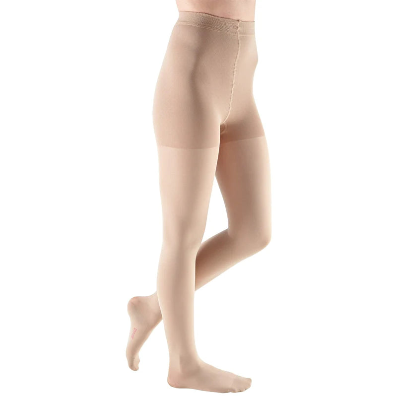 Compression maternity pantyhose in beige with closed toe and adjustable waistband, shown on a side-facing model