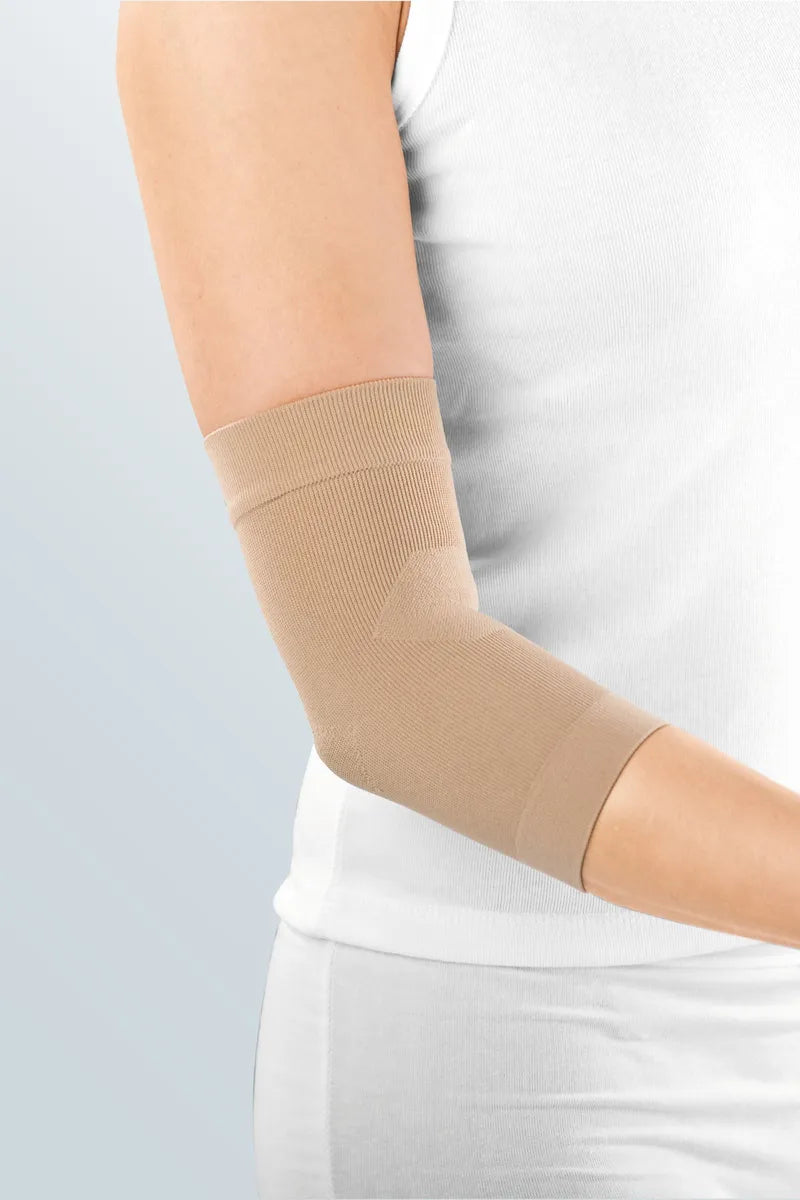 Elbow support sleeve in beige knit fabric worn on a bent arm, shown against a light gray background