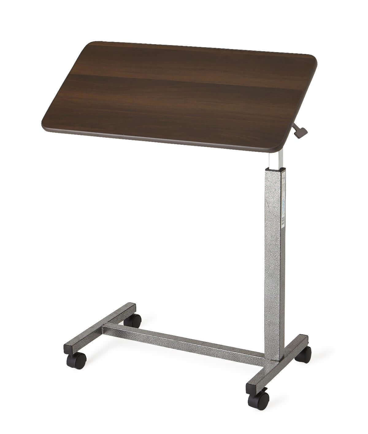 Overbed table with tilting walnut-finish top, height-adjustable silver metal post, H-base frame, and four rolling casters