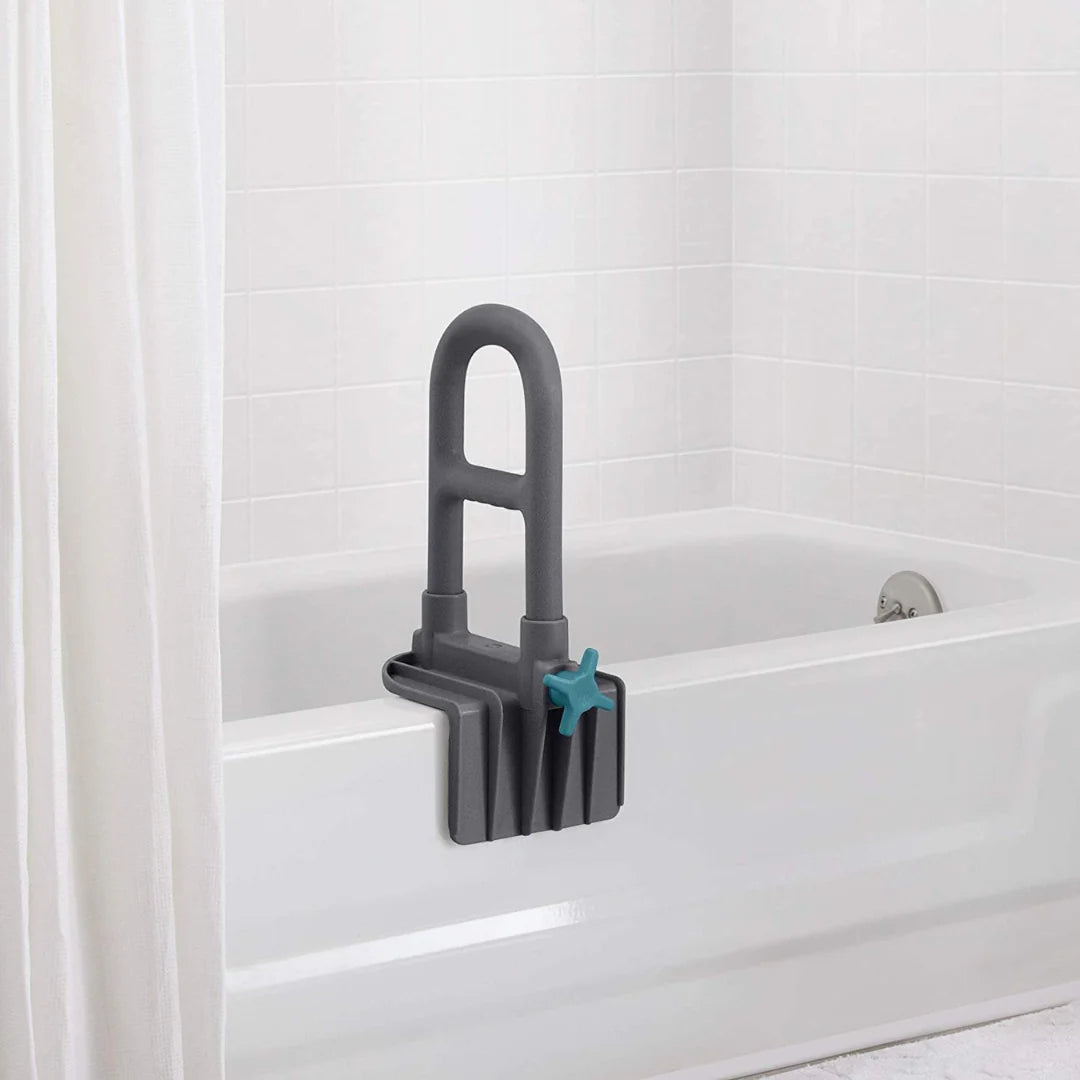 Bathtub grab bar in gray with teal tightening knob, clamped onto the side of a white bathtub near a shower curtain