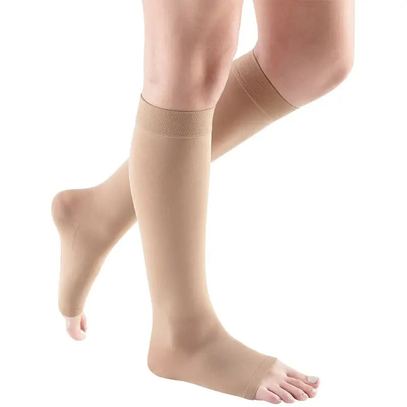 Compression knee-high stockings in beige with open toe design, worn on a person's legs, shown from both front and side angles