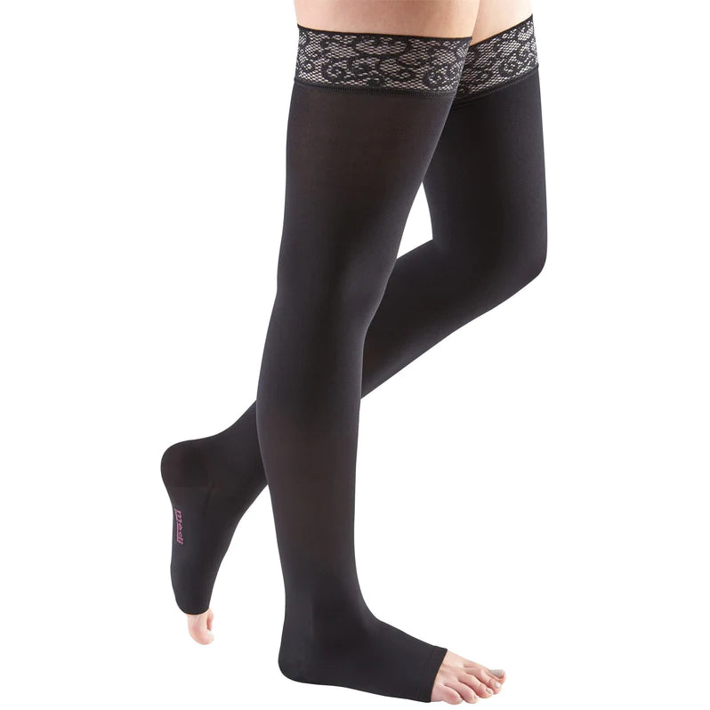 Compression thigh-high stockings in black with lace silicone top band and open toe, shown on a woman's legs