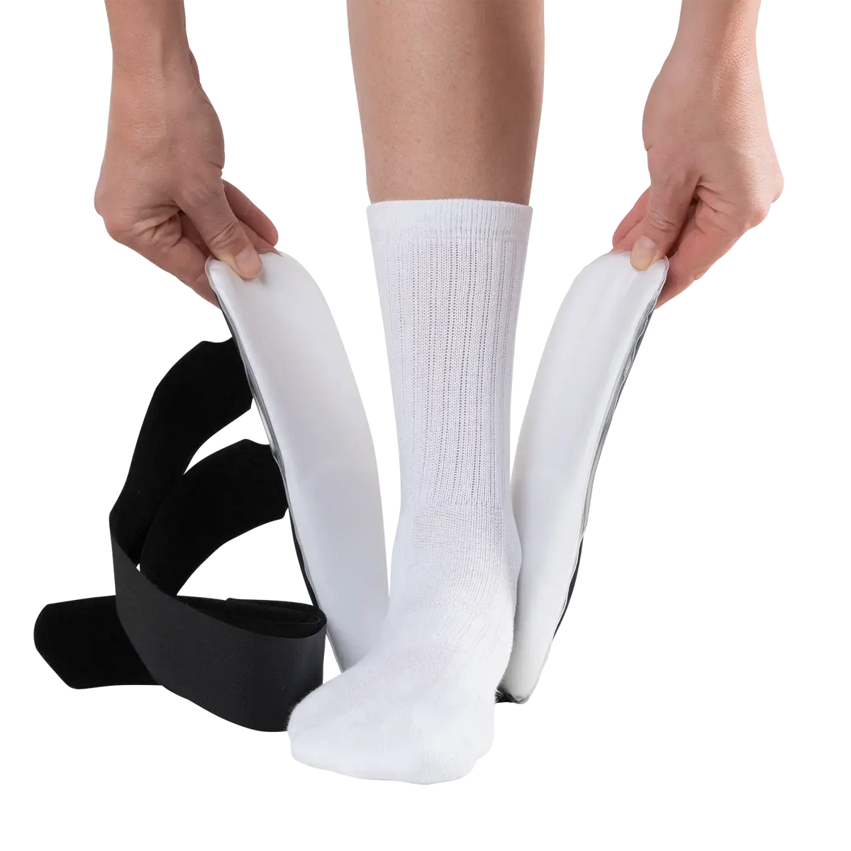 Ankle stirrup brace being applied to a white-socked foot, with hands holding open the padded side panels