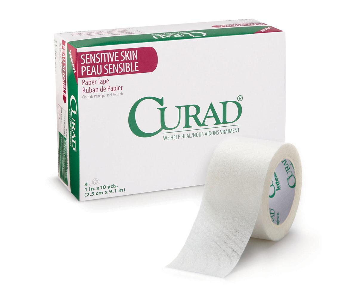 Medical paper tape roll beside its white and green Curad Sensitive Skin boxed packaging on a white background