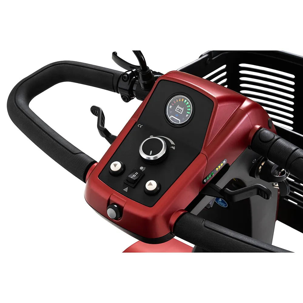 Power scooter tiller control panel in red with speed dial, battery gauge, toggle switches, and front basket visible