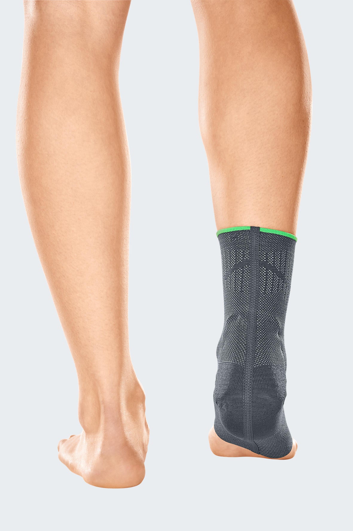 Ankle support brace in gray knit fabric with green trim worn on right foot, rear view showing Achilles coverage