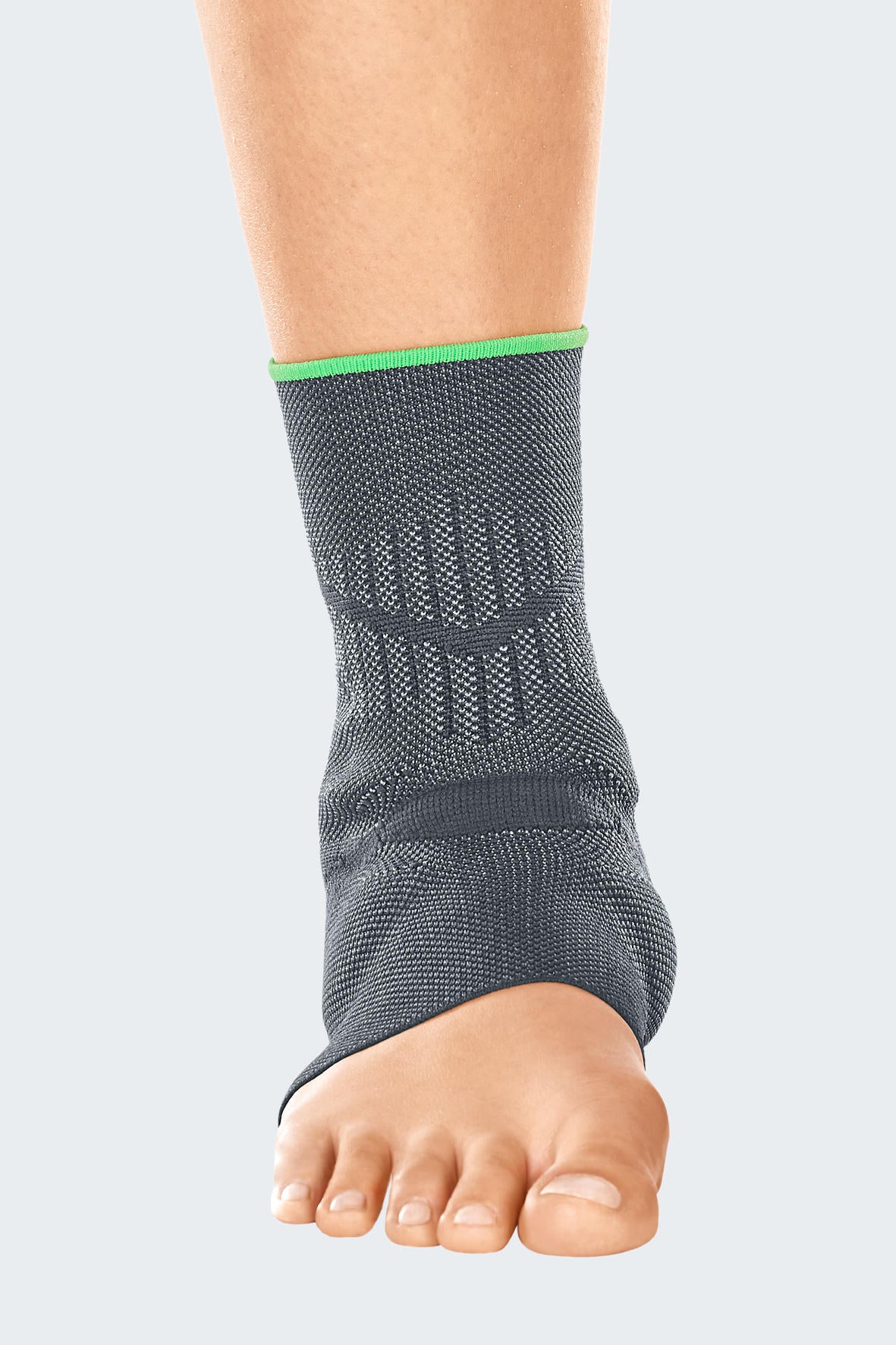 Ankle support in gray knit fabric with green trim worn on a bare foot and lower leg, open-toe design