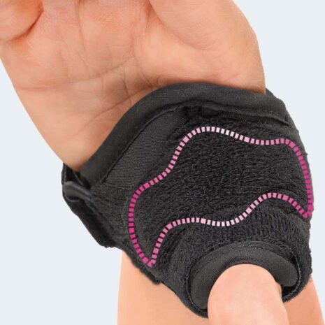 Rhizomed Soft Thumb Support in black with pink stitching worn on a hand, securing the thumb and wrist