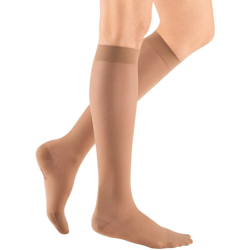 Knee-high compression stockings in sheer beige worn on a person's lower legs, shown from two angles with a banded top cuff
