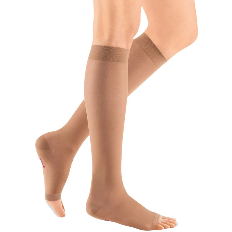 Compression knee-high stockings in beige, open-toe style, worn on a woman's legs, shown from the knee down