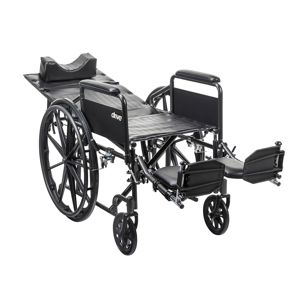 Reclining wheelchair with black frame, fully reclined back, padded headrest, elevating leg rests, and large rear wheels