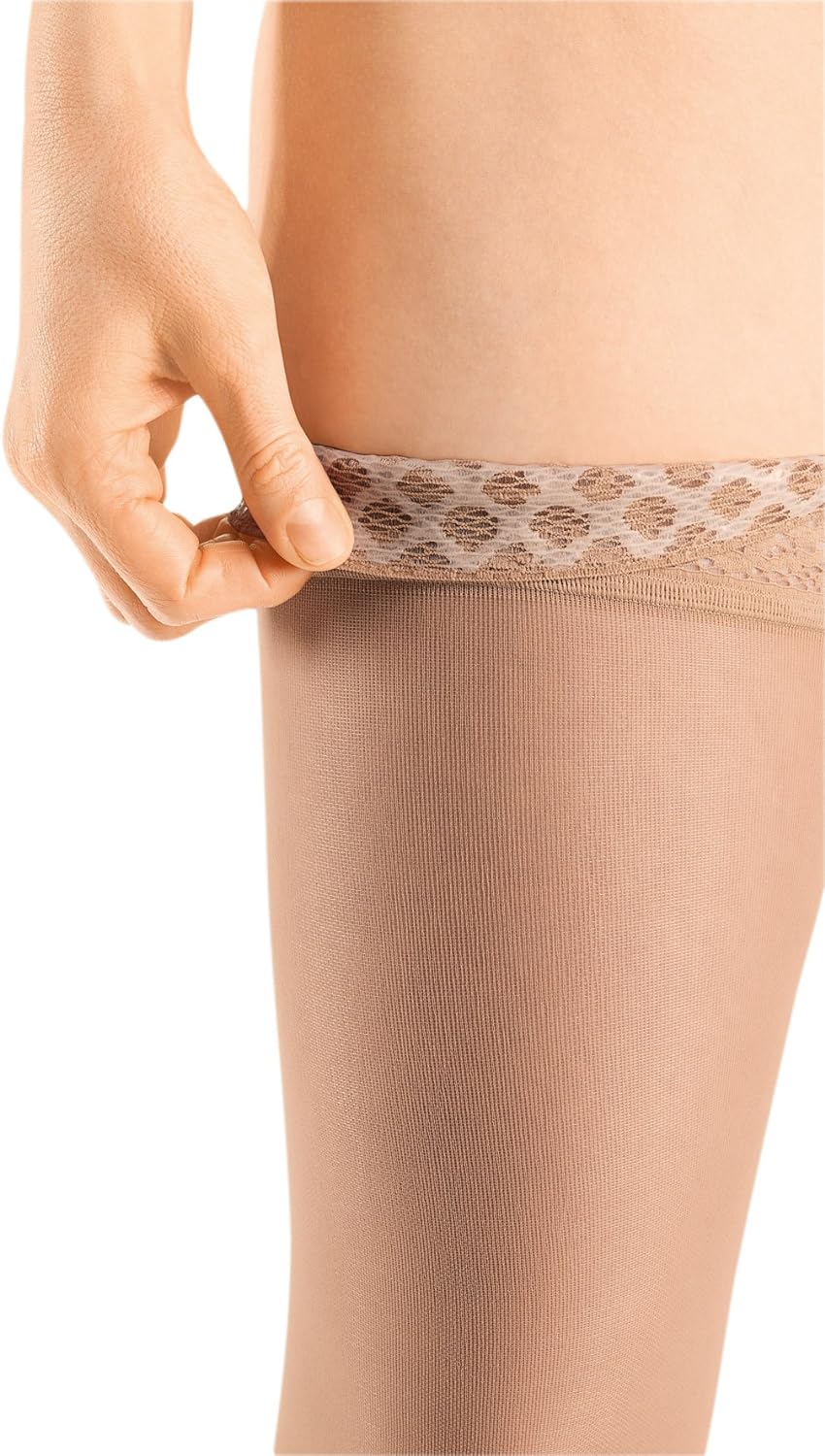 Thigh-high compression stocking in beige with lace silicone top band being pulled up onto a leg