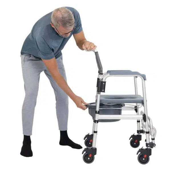 Shower commode transport wheelchair with older man adjusting the aluminum frame, featuring locking casters and padded seat