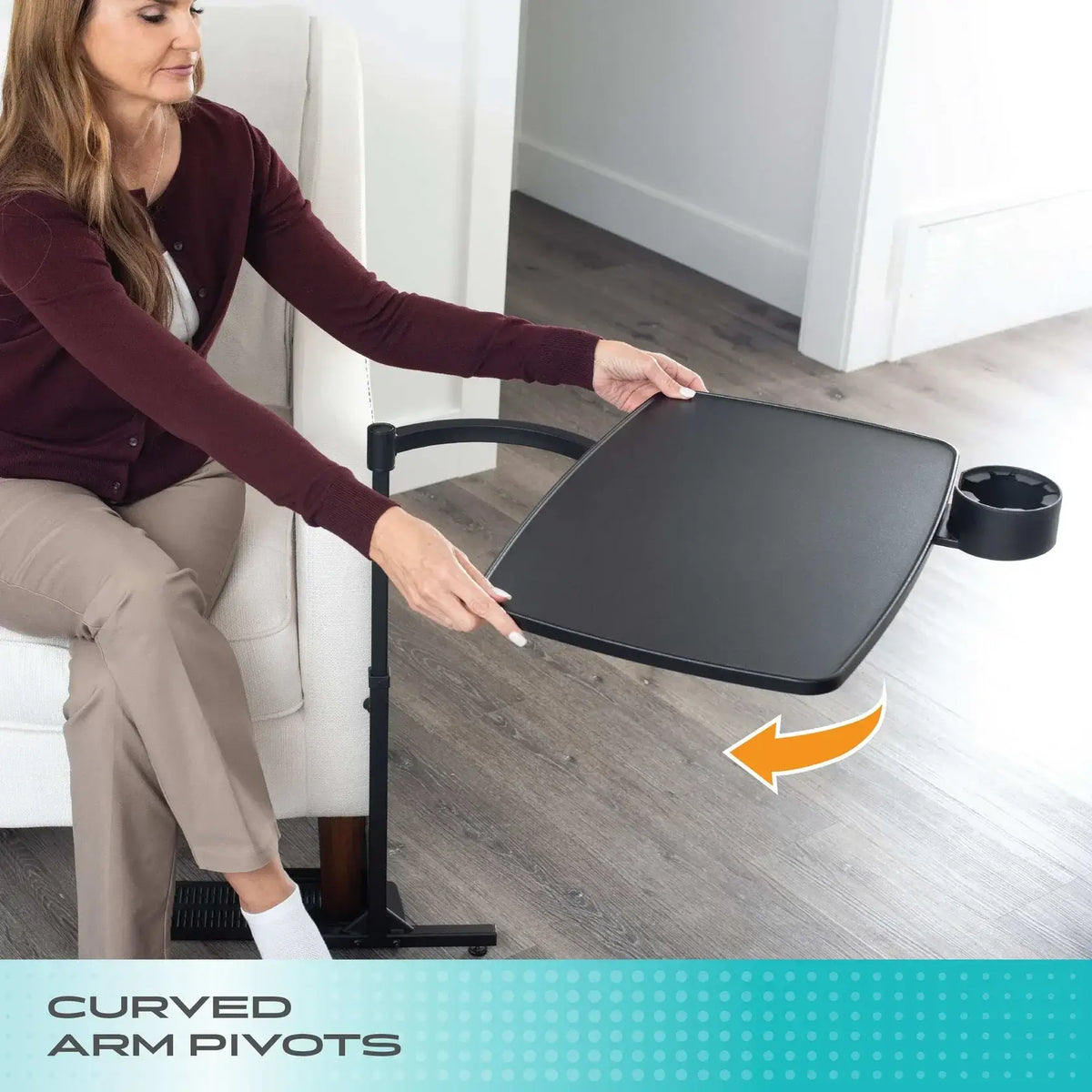 Overbed table with curved arm pivots being adjusted by a seated woman, showing swivel tray with cup holder on rolling stand