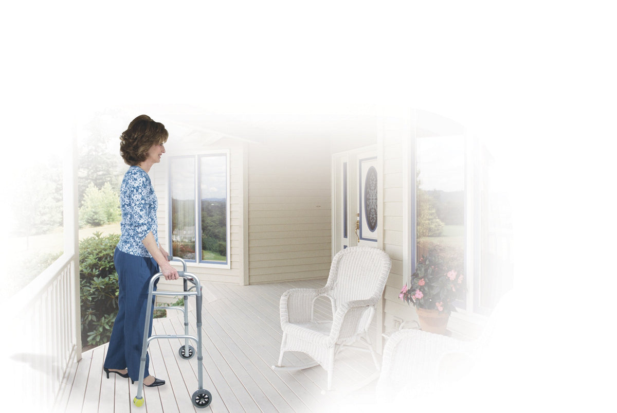 Walker with swivel lock front wheels used by a woman standing on a home porch near a front door