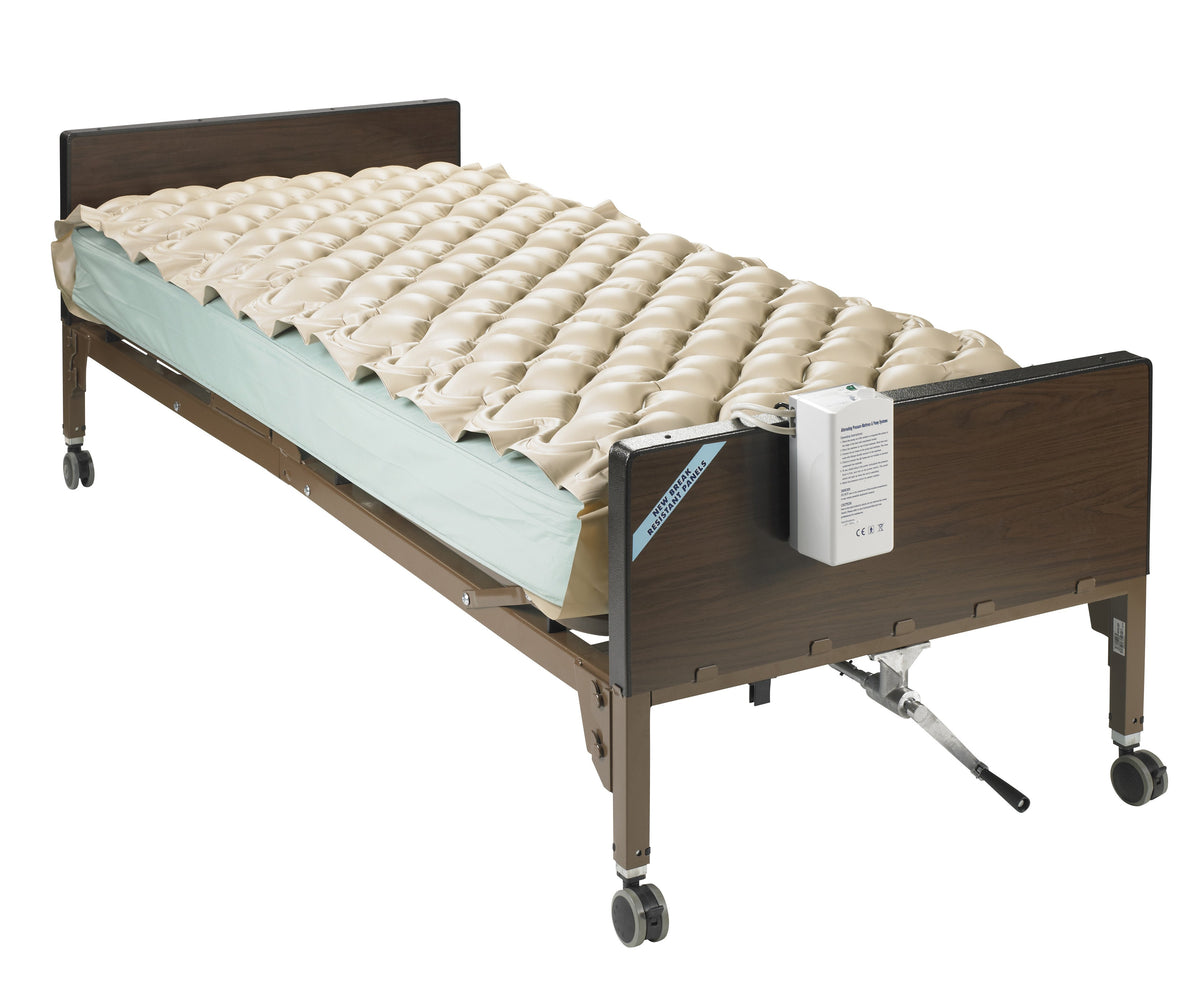 Alternating pressure pad system with bubble surface on a wood-frame hospital bed with electric pump unit attached to