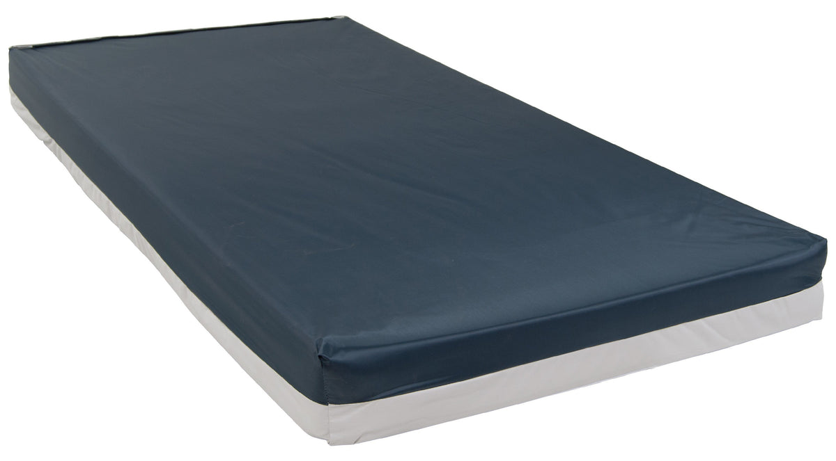 Bariatric foam mattress with navy blue vinyl cover and white base, shown at an angle on white background