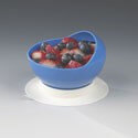 Scooper plate with high curved inner wall in blue, filled with berries, on a clear suction cup base