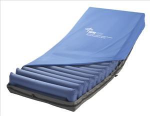 Low-air-loss mattress with blue cover and alternating air cell channels on a dark base frame