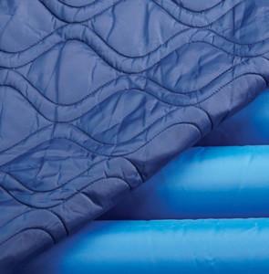 Pressure relief overlay with quilted dark blue fabric top layer folded back to reveal blue air chambers beneath