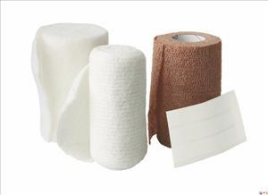 Compression bandage kit with two rolled gauze bandages in white and tan beside a folded wound pad on white background