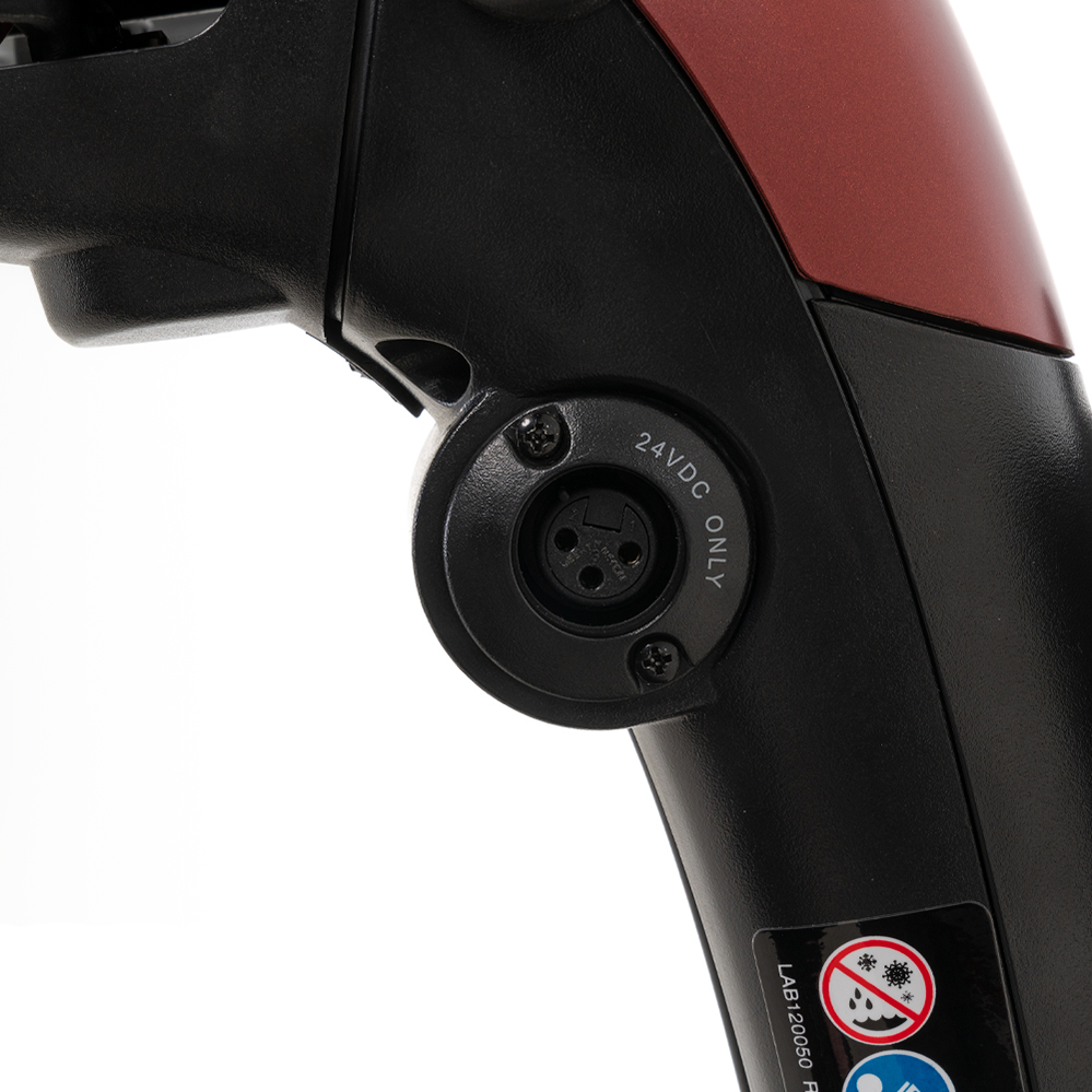 Power scooter tiller close-up showing 24VDC charging port with XLR connector on black and red housing