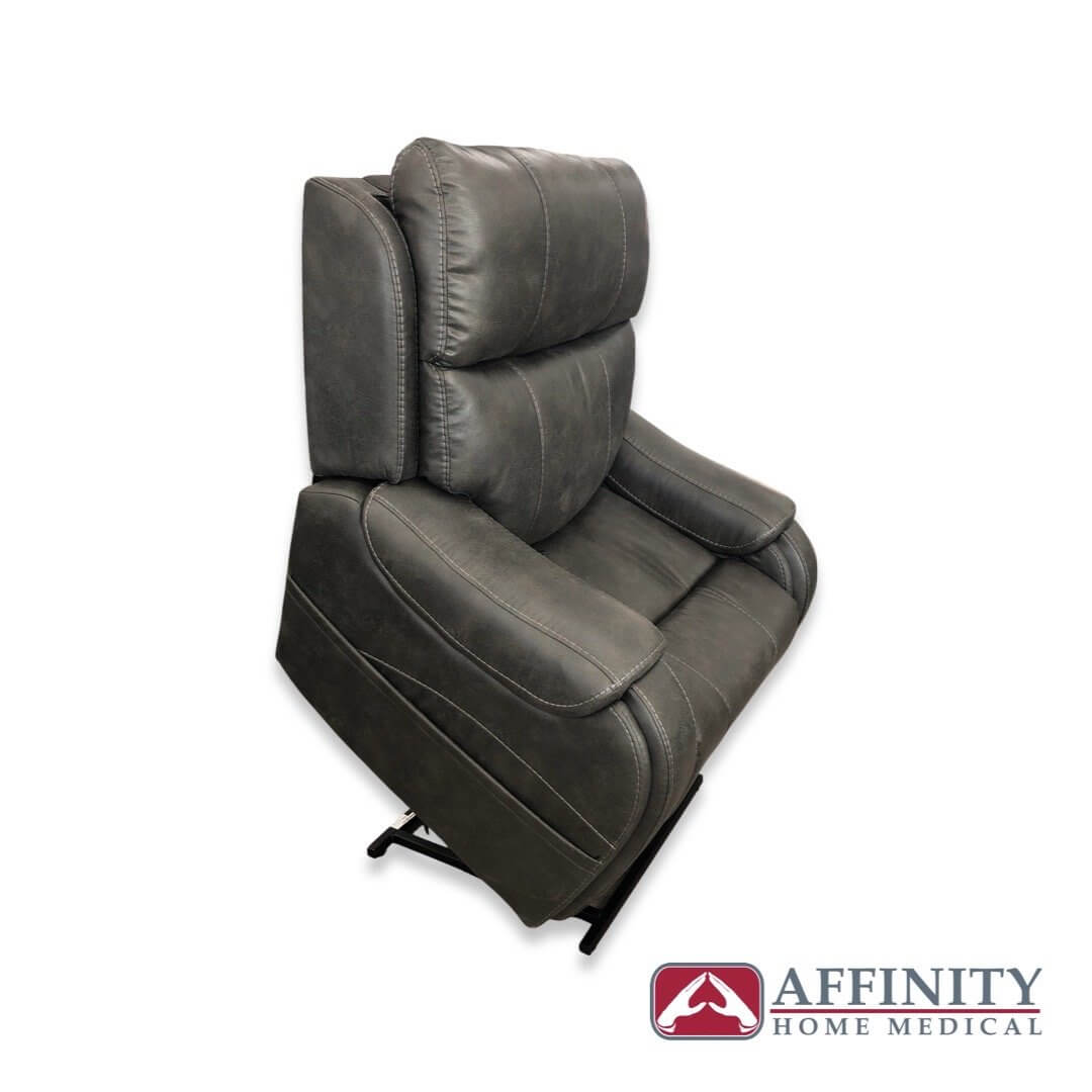 Power lift recliner chair in gray suede fabric, shown from a side angle in the upright seated position with padded armrests